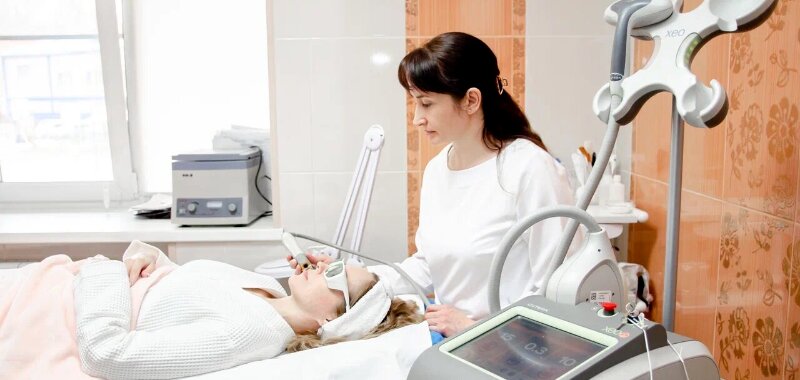 опытный косметолог дерматолог лечит угревую болезнь лазером